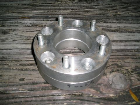 1978 Ford Bronco - Wheel spacer with '5 on 5.5' marking, shown on a wooden background.