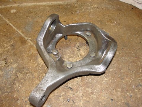1995 Ford Bronco - A close-up view of a metal steering knuckle, a component of a vehicle's suspension system.