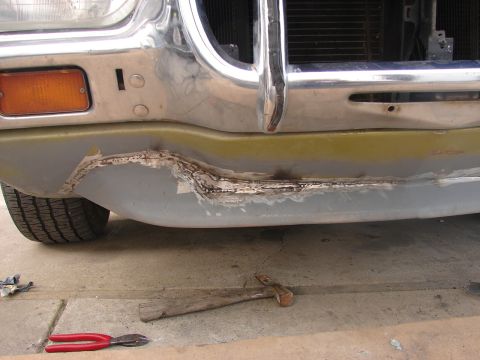 1973 Ford Ranchero - Front bumper of a 1973 Ford Ranchero being repaired, with tools visible on the ground.