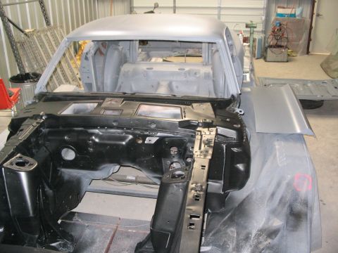 1970 Ford Mustang - The front section of a car body, likely a 1970 Ford Mustang, is shown in primer during restoration work.