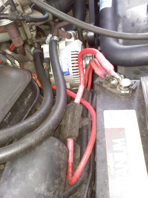 1992 Ford Bronco - Close-up view of an engine bay, focusing on the alternator, battery terminals, and associated wiring.