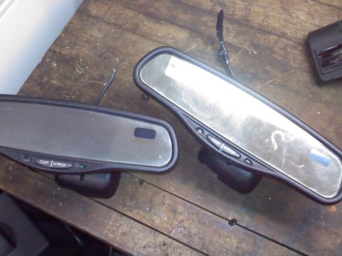 1992 Ford Bronco - Two auto-dimming rearview mirrors with control buttons are shown on a wooden table.