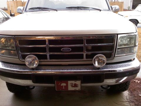 1992 Ford Bronco - The grille and headlights of a white Ford truck are shown, with a South Carolina license plate mounted on the front bumper.