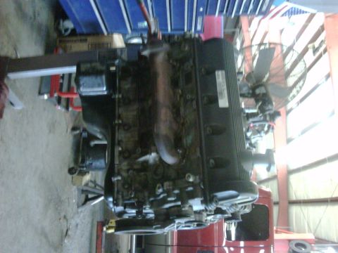 2005 Ford Crown Victoria - Engine assembly on a stand in a workshop environment, with various tools and equipment in the background.