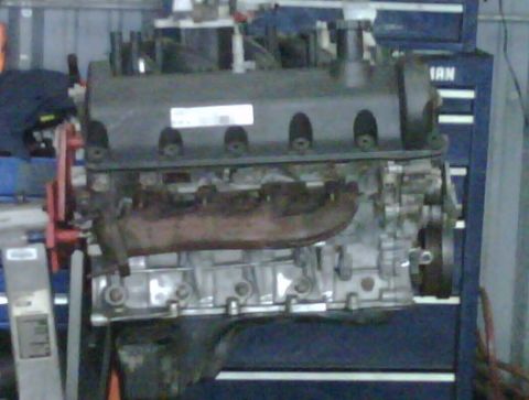 2005 Ford Crown Victoria - Engine block is shown on a stand in front of a blue toolbox.