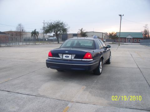 2005 Ford Crown Victoria - Rear view of a dark blue Ford Crown Victoria, likely a police interceptor model, in a paved lot.