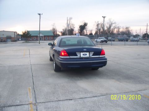 2005 Ford Crown Victoria - This Ford Crown Victoria is seen from the rear in a parking lot with buildings and trees in the background.