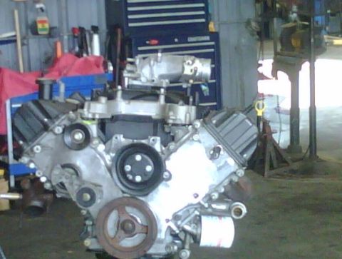 2005 Ford Crown Victoria - Engine assembly on a stand in a garage, with tools and equipment in the background.