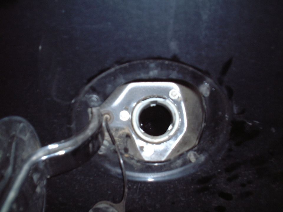 Close-up of chrome hex fitting with open bore on a dark wet surface