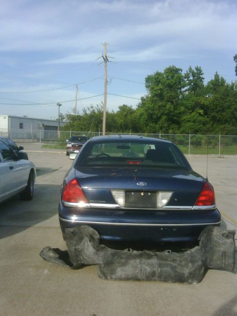 2005 Ford Crown Victoria - Rear view of a Ford Crown Victoria with its bumper removed, parked next to another vehicle.