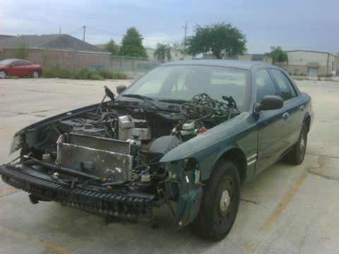 2005 Ford Crown Victoria - This 2005 Ford Crown Victoria is missing its front bumper and has its hood open, revealing its engine components.