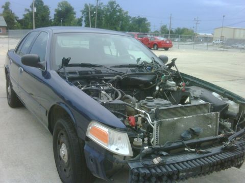 2005 Ford Crown Victoria - This 2005 Ford Crown Victoria is shown with its hood open, revealing the engine compartment and damage to the front end.