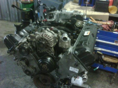 2005 Ford Crown Victoria - Engine assembly with visible components like alternator and pulleys, and a label reading "47POL".