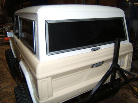 1988 Ford Bronco - RC crawler model SUV with a tan lower body and white upper body, viewed from the rear.
