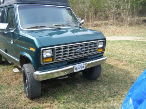 1981 Ford E350 - The front grille and headlights of a green van are visible, with a Virginia license plate.