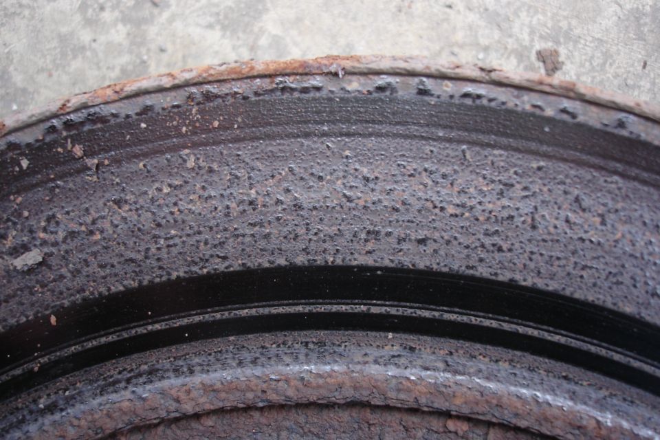 Close-up of a heavily rusted brake rotor with pitting and corrosion