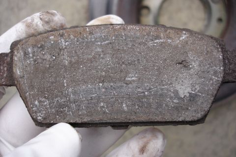 2006 Ford Fusion - A close-up of a used brake pad, indicating wear and tear.