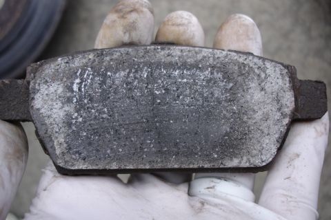 2006 Ford Fusion - A close-up view of a worn brake pad, showing significant wear and tear.