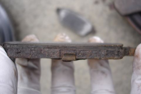2006 Ford Fusion - A close-up view of a heavily worn brake pad, indicating the need for replacement.