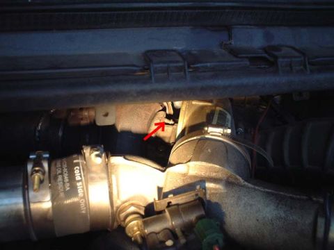 2000 Ford Excursion - Close-up view of engine components, with a red arrow indicating a specific area of interest on a pipe.