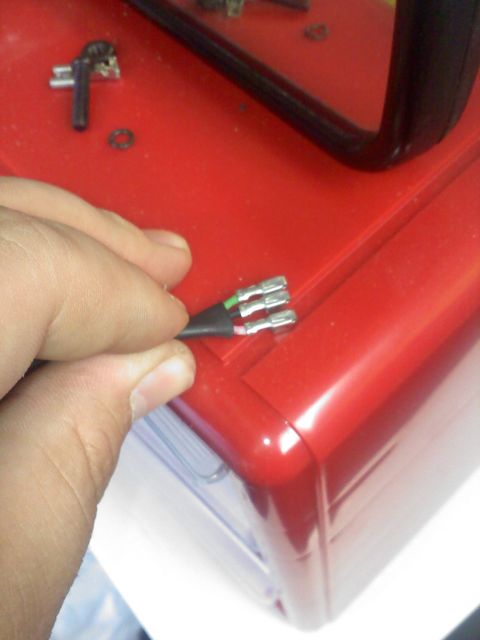 1977 Ford F-100 - A hand connects an electrical cable with spade terminals to a red housing.
