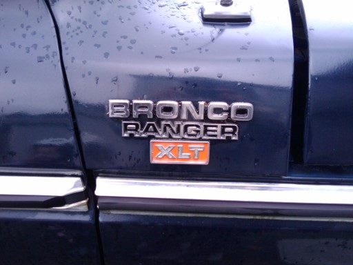 Close-up of 1979 Ford Bronco Ranger XLT badge on dark blue paint
