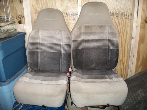 1990 Ford Explorer - Two cloth car seats with 'Eddie Bauer' stitching and plaid fabric are shown.