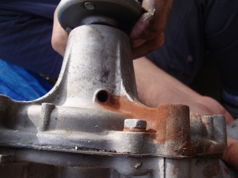 1989 Ford Taurus - A close-up view of a metal automotive part showing signs of rust and a bolt. The registry information for this part is unconfirmed.