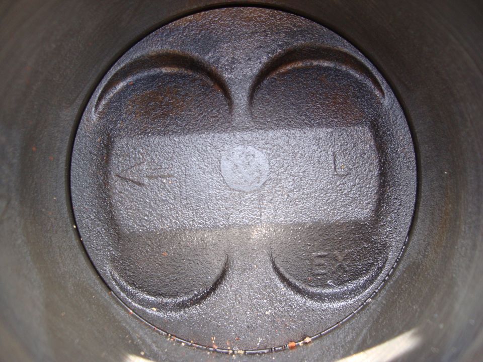 Piston top with intake and exhaust valve reliefs, marked 'L' for left cylinder