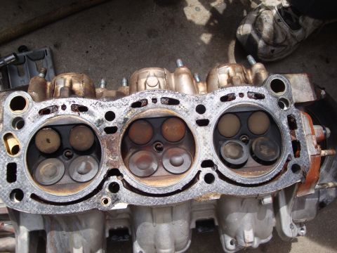 1989 Ford Taurus - Close-up view of an engine cylinder head, revealing the internal components of the combustion chambers.