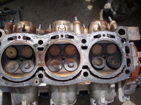 1989 Ford Taurus - Close-up view of an engine cylinder head, showing the valves within the combustion chambers.
