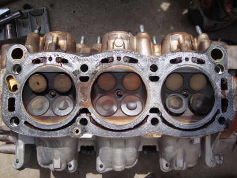 1989 Ford Taurus - Close-up of a used engine cylinder head, showing wear on the valves.