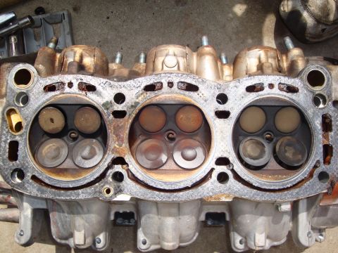 1989 Ford Taurus - Close-up view of a disassembled engine cylinder head, showing the intake and exhaust valves.