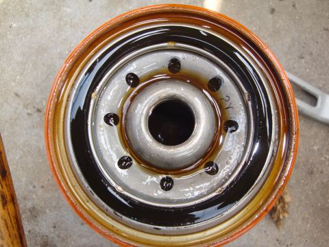 1989 Ford Taurus - Close-up of a used oil filter, showing the metal filter element and the oil it has collected.