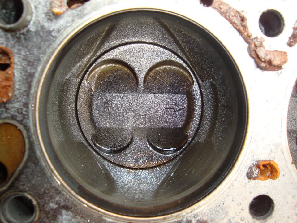 Engine cylinder with piston showing R and an arrow marking