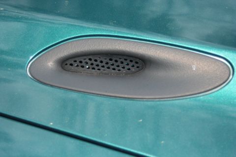 1976 Ford Ranchero - Detail of a vent on the fender of a teal-colored vehicle.
