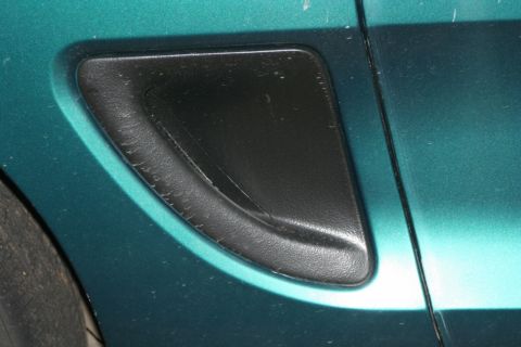 1976 Ford Ranchero - Close-up of a black vent on the side of a teal vehicle, with a portion of the tire visible.