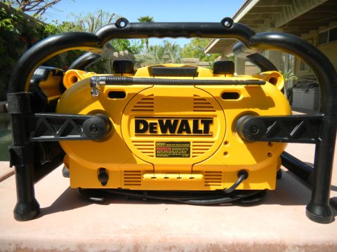 1997 Ford Ranger - Rear view of a yellow-and-black DeWalt DC011 worksite radio/charger in its roll-cage frame, showing the telescoping antenna, coiled power c…