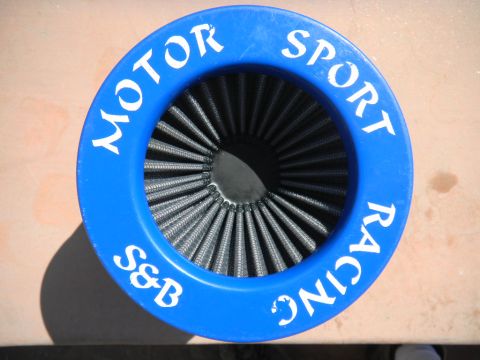 1997 Ford Ranger - Top-down view of a round S&B Motor Sport Racing conical air filter with a blue urethane top cap lettered in white and dark pleated cotton-g…