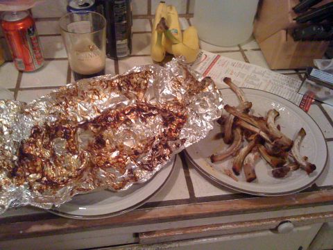 1989 Ford Bronco - A plate of leftover rib bones sits next to a pile of used aluminum foil on a tiled countertop, with drinks and bananas in the background.