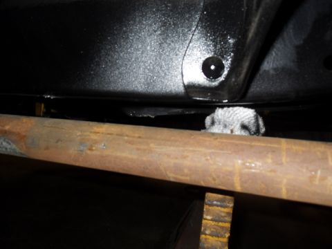 1997 Ford Ranger - A rag is visible peeking out from under a rusty pipe on the undercarriage of a vehicle.