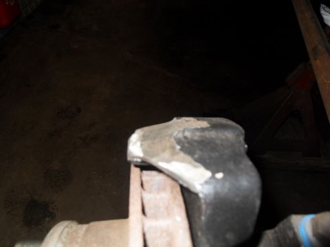 1997 Ford Ranger - A close-up view of a rusty metal part, likely a vehicle suspension component, secured in a vise.