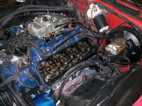 1973 Ford Ranchero - Close-up view of an engine bay a blue intake manifold, carburetor, and visible valve train components.