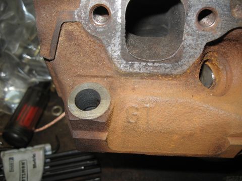 1994 Ford Bronco - Close-up of a rusty engine component showing the letters 'GT' cast into its surface.