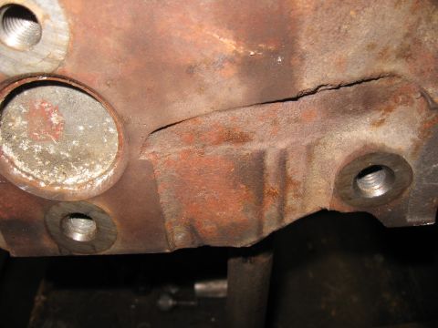 1994 Ford Bronco - This image shows a heavily rusted engine block casting with a crack and bolt holes.
