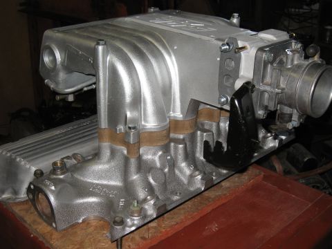 1994 Ford Bronco - A silver GT40 intake manifold with a throttle body is shown, likely a performance upgrade part.