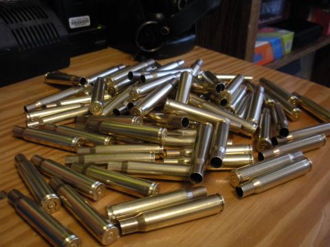 1996 Ford Bronco - A collection of spent shell casings lies scattered on a wooden surface.