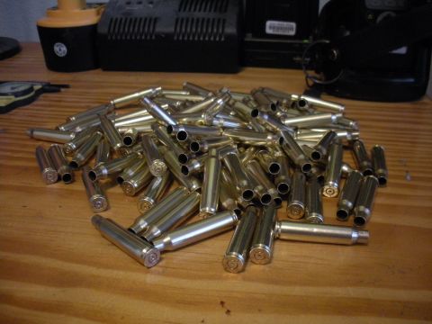1996 Ford Bronco - A large pile of spent bullet casings sits on a wooden table, with some electronic equipment in the background.