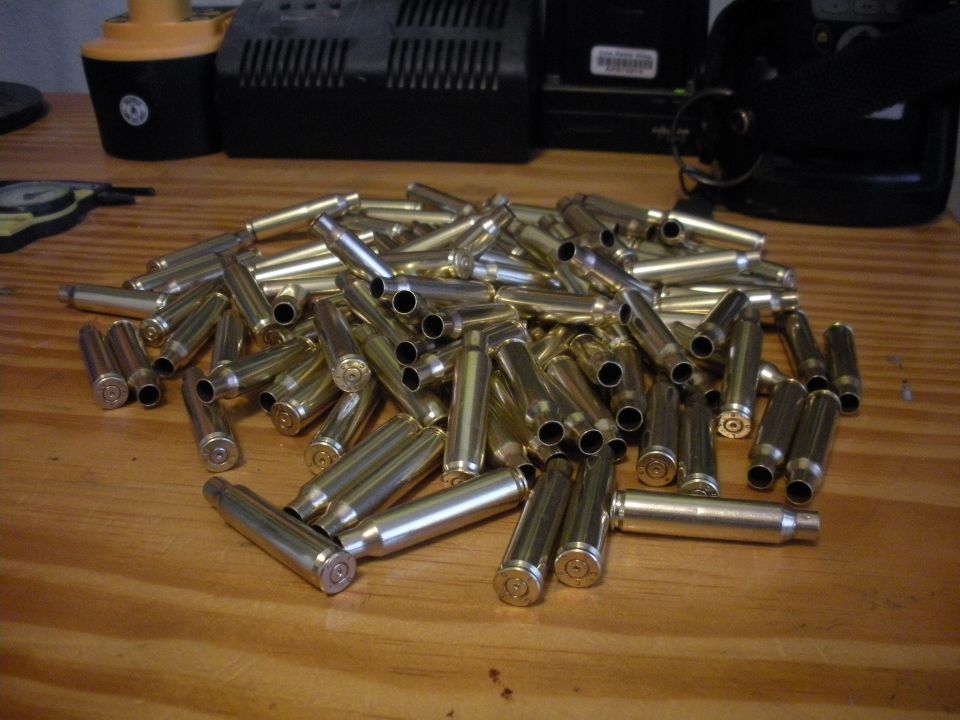 Pile of spent bullet casings on a wooden surface