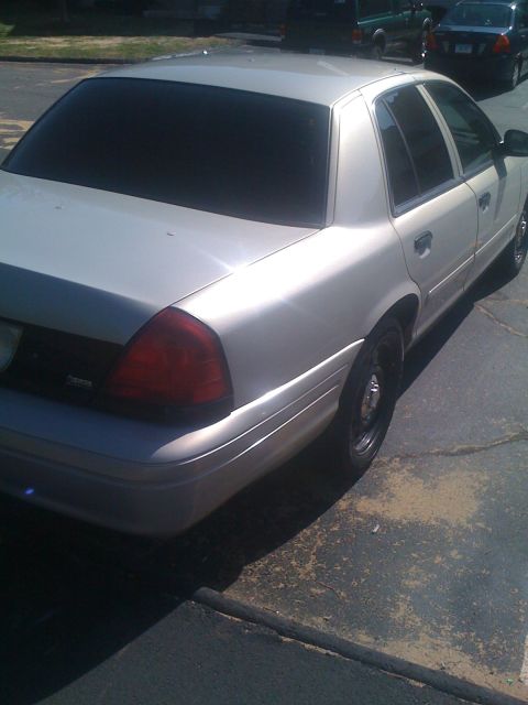 2009 Ford Crown Victoria - Rear view of a silver 2009 Ford Crown Victoria with tinted windows parked on pavement.